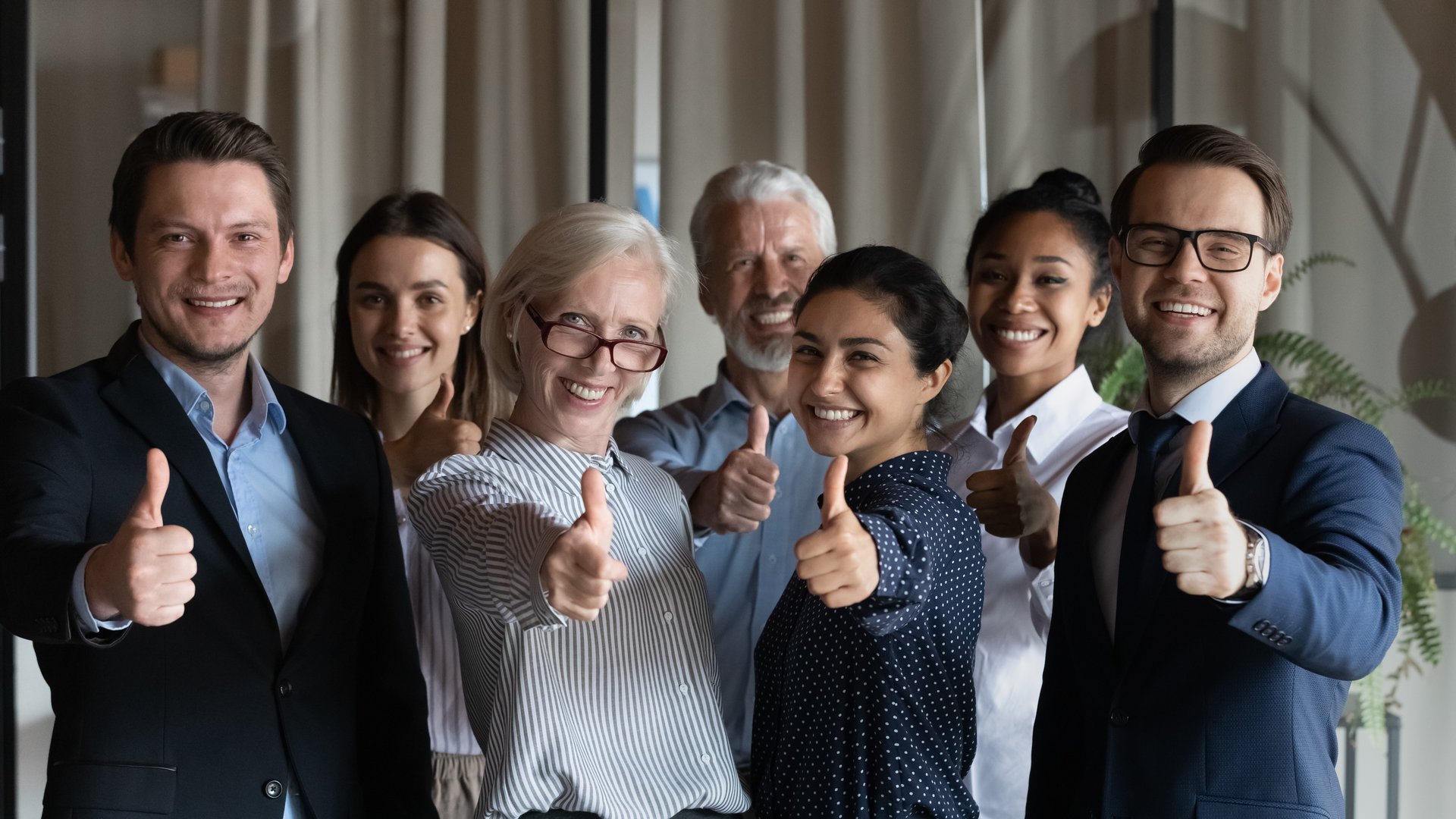 Happy successful diverse businesspeople employees group showing thumbs up together, looking at camera, standing in office, excited colleagues team recommending best corporate service, good career Zaufali nam